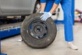 Mechanic with wheel tire at car workshop Royalty Free Stock Photo