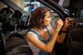 Mechanic woman in a blue overalls repair the door of car