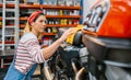 Mechanic woman cleaning motorcycle seat with cloth on factory Royalty Free Stock Photo