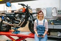 Mechanic woman holding digital tablet sitting over platform Royalty Free Stock Photo