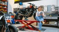 Mechanic woman holding digital tablet sitting over platform Royalty Free Stock Photo