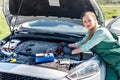 Mechanic - woman tests motor with tester