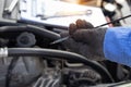 Mechanic at work in his garage auto check up and car service shop concept. Close up hand mechanic checking oil level in a engine Royalty Free Stock Photo