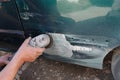 Mechanic worker repairman sanding polishing car body and preparing automobile for painting during repair Royalty Free Stock Photo