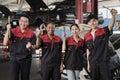 Mechanic workers team celebrating after-work success at a service car garage.