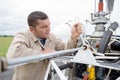 mechanic working on aircraft outdoors on airfield Royalty Free Stock Photo