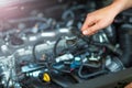 Mechanic working on car engine in auto repair shop