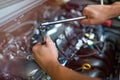 Mechanic working on car engine in auto repair shop