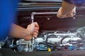 Mechanic working on car engine in auto repair shop