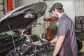 Mechanic working on car in his shop Royalty Free Stock Photo