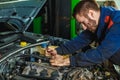 Mechanic working in car motor.