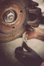 Mechanic working at a car worn and rusty brake disk and caliper Royalty Free Stock Photo