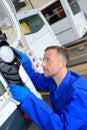 Mechanic working on rear light bus Royalty Free Stock Photo