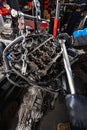 Mechanic Working on Suspended Car Engine with Manual Hoist