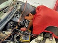 The mechanic works to fix the damaged car