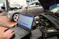 mechanic in a workshop checks and checks the electronics of the car - software update with a modern computer Royalty Free Stock Photo