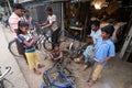 Mechanic in workshop repairing bicycle, Kumrokhali, India