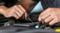 Close-up of mechanic's hands using tools to replace spark plugs in a car engine, ensuring smooth operation and Royalty Free Stock Photo