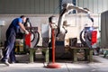 Man and robotic machine work together inside industrial building.