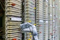 The mechanical arm of the robot is next to the switchboard of the ip telephony. The robot works in the server room of the data Royalty Free Stock Photo