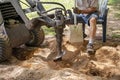 A Mechanical Auger Digging A Post Hole