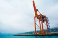 mechanical crane lifting freight at pier