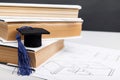 Mechanical drawings and graduation cap on books. Engineering education concept