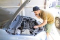 Mechanical fixing car at home. Repairing Service advice by mobile phone. Mechanic, technician man checking car engine. Car service Royalty Free Stock Photo