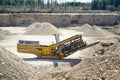 Mechanical machine, conveyor belt for transporting and crushing stone with sand. Mining quarry for the production of crushed stone Royalty Free Stock Photo