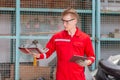 Mechanical man with digital tablet inspecting car parts stock in garage warehouse, Young mechanic working in auto repair shop Royalty Free Stock Photo