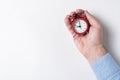 Mechanical red alarm clock in male hands on white background. Time management concept. Top view Royalty Free Stock Photo