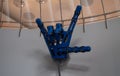 A mechanical robotic arm shows a punk rock devil horn gesture. An exhibit of a large mechanical arm was jokingly folded