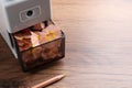 Mechanical sharpener with pencil shavings on wooden table. Space for text