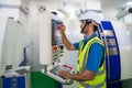 Mechanical technician operative entering data in cnc milling cutting machine at factory at tool workshop in metal machining