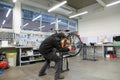Mechanical workshop with the mechanic adjusting an orange bicycl
