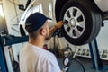 Mechanician changing car wheel in auto repair shop