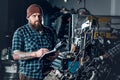 Mechanicl inspecting engine of a car in a garage.