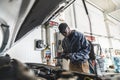 Mechanics checking car engine under the open hood Royalty Free Stock Photo