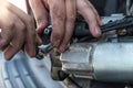 Mechanics with dirty hands repair broken starter on car/ Automotive service