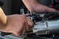 Mechanics with dirty hands repair broken starter on car/ Automotive service