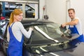 Mechanics or glaziers install windshield or windscreen on car Royalty Free Stock Photo