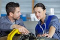 Mechanics instructor teaching woman in apprenticeship