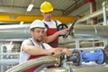 Mechanics repair a machine in a modern industrial plant - profession and teamwork - portrait group workman