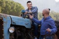 Mechanics reparing old agrimotors at farm