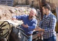 Mechanics reparing old agrimotors at farm