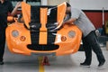 Mechanics working on a sports car with an open bonnet in a garage Royalty Free Stock Photo