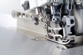 Mechanism of an industrial overlock sewing machine - closeup view on foot and needles with blurred background Royalty Free Stock Photo