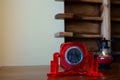 Antique table clock in a red frame on the table.