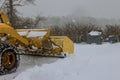 Mechanized tractor for snow removal is parked on a city street after snowfall