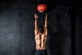 Young strong sweaty focused fit muscular man with big muscles doing throwing medicine ball up on the wall for training hard core w Royalty Free Stock Photo